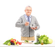 Mature smiling gentleman preparing a fresh salad