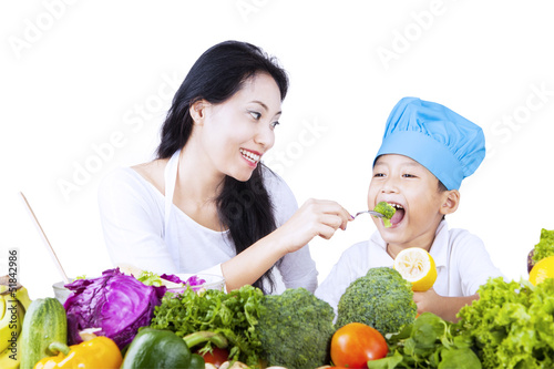Photo: Mother feed young chef Mother feed young chef