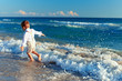 Photo: happy baby boy having fun on the beach. Focus on surf happy baby boy having fun on the beach. Focus on surf