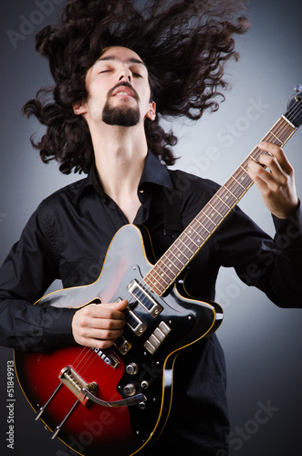 Photo: Man playing guitar during concert Man playing guitar during concert