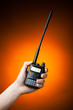 professional walkie-talkie radio in hand on orange background