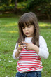 young girl creating a ring with a daisy flower