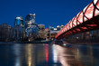 Calgary skyline and pedestrian bridge at night.