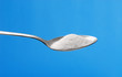 Foto: Cucharilla con una porción de azúcar.cuchara de azúcar. Cucharilla con una porción de azúcar.cuchara de azúcar.