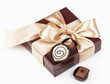brown box with candies and golden tape on a white background