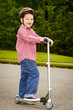Photo: Child with safety helmet riding scooter outdoors Child with safety helmet riding scooter outdoors