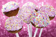 Pink cake pops decorated with colorful sprinkles