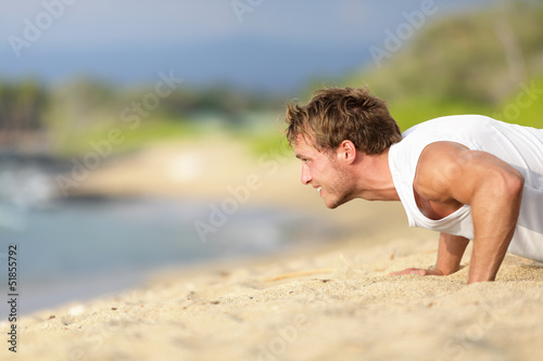 Photo: Push-ups - man fitness model training on beach Push-ups - man fitness model training on beach