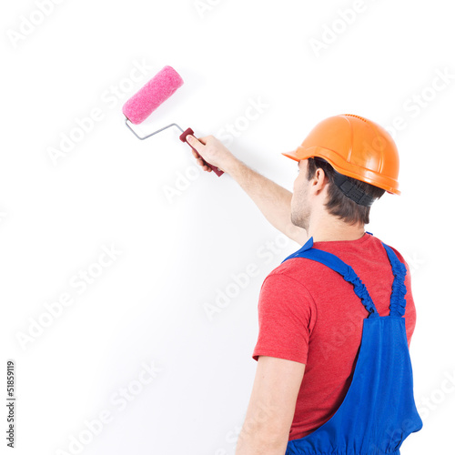 Photo: Craftsman painter stands on the stairs with roller Craftsman painter stands on the stairs with roller