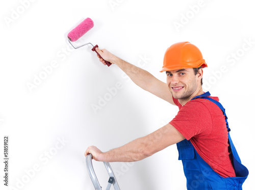 Photo: Craftsman painter stands on the stairs with roller Craftsman painter stands on the stairs with roller