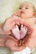 father hands holding small baby's feet
