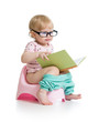 baby girl sitting on chamberpot with book