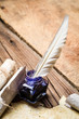 Photo: Blue ink with feather on old wooden table Blue ink with feather on old wooden table