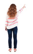 Back view of  pointing woman. beautiful redhaired  girl