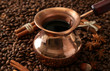 Pot of coffee on coffee beans background