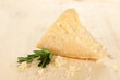 Piece of Parmesan cheese on wooden table close-up