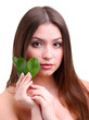 Beautiful young woman with green leafs isolated on white