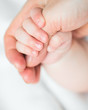 baby holds mother's finger