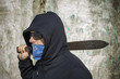 Photo: Man with a machete on shoulder on a wall background Man with a machete on shoulder on a wall background