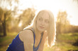 Beautiful blonde girl model looks away in the sun rays
