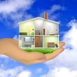Woman's hand holding a house cut with interiors
