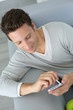 Photo: Man relaxing in sofa and reading his emails Man relaxing in sofa and reading his emails