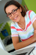 Foto: Cheerful girl with eyeglasses working on laptop Cheerful girl with eyeglasses working on laptop