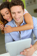 Cheerful couple with tablet shopping on internet