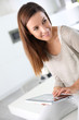 Young cheerful woman using electronic tablet