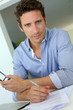 Man with blue shirt working on laptop