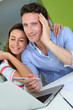 Foto: Couple at home sitting in front of laptop Couple at home sitting in front of laptop