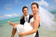 Groom holding his bride by the Caribbean sea