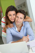 Foto: Couple at home sitting in front of laptop Couple at home sitting in front of laptop