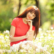 Foto: Cute woman in the park with dandelions Cute woman in the park with dandelions