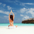 woman doing yoga exercises on the beach