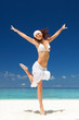 Photo: happy young woman jumping on the tropical beach happy young woman jumping on the tropical beach