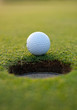 Golf ball by the hole