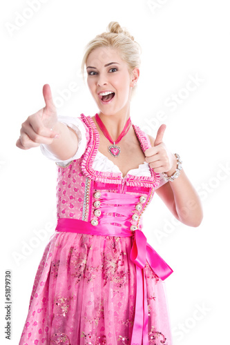 Photo: Frau blond im Dirndl mit Daumen isoliert in Pink Frau blond im Dirndl mit Daumen isoliert in Pink