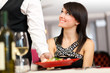 Foto: Waiter serving a woman in a restaurant Waiter serving a woman in a restaurant