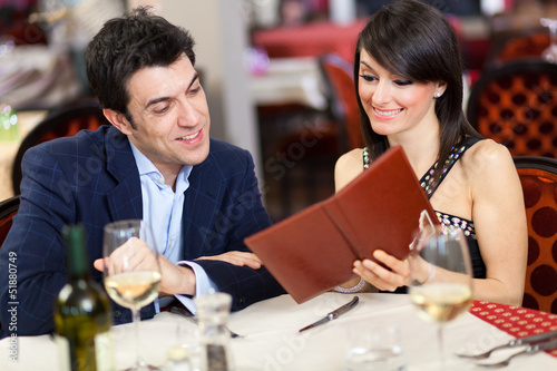 Photo: Couple choosing on the menu in a restaurant Couple choosing on the menu in a restaurant