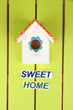 Decorative nesting box and sign on color background