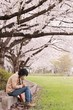 さくらの木の下に座る人