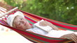 Video: Senior Woman Relaxing In Hammock With Book Senior Woman Relaxing In Hammock With Book