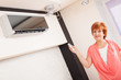 Foto: Woman holding a remote control air conditioner Woman holding a remote control air conditioner