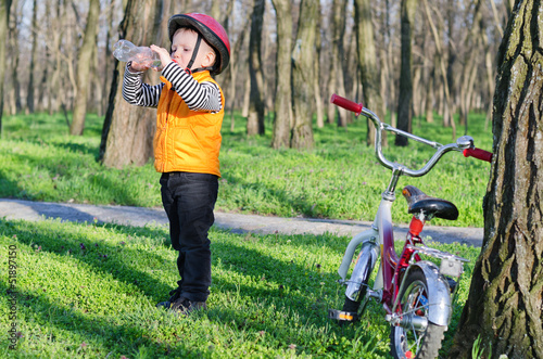Photo: Thirsty little boy drinking bottled water Thirsty little boy drinking bottled water