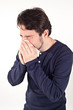 Man with cold holding tissue