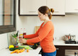  woman washing vegetables in  kitchen