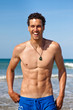 Handsome fit young man laughing on the beach