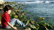 Little boy throwing stones into the sea