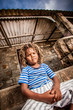 Rasta little boy sulking on the porch